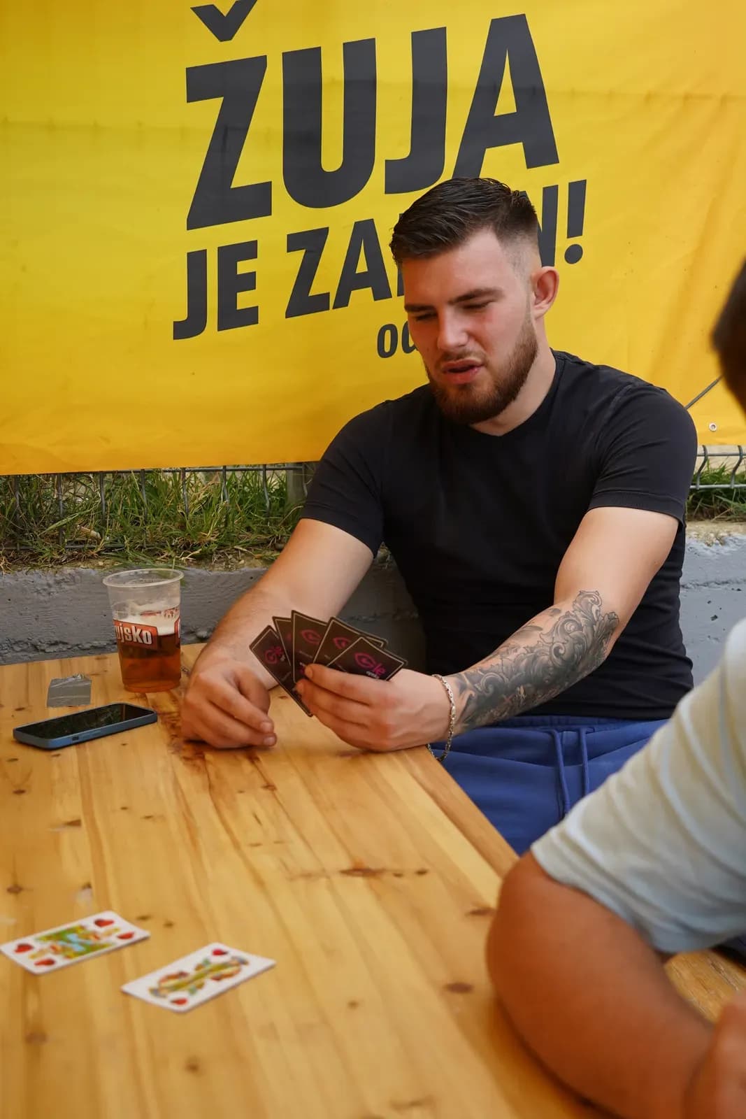 Igrač drži karte za belu za stolom turnira